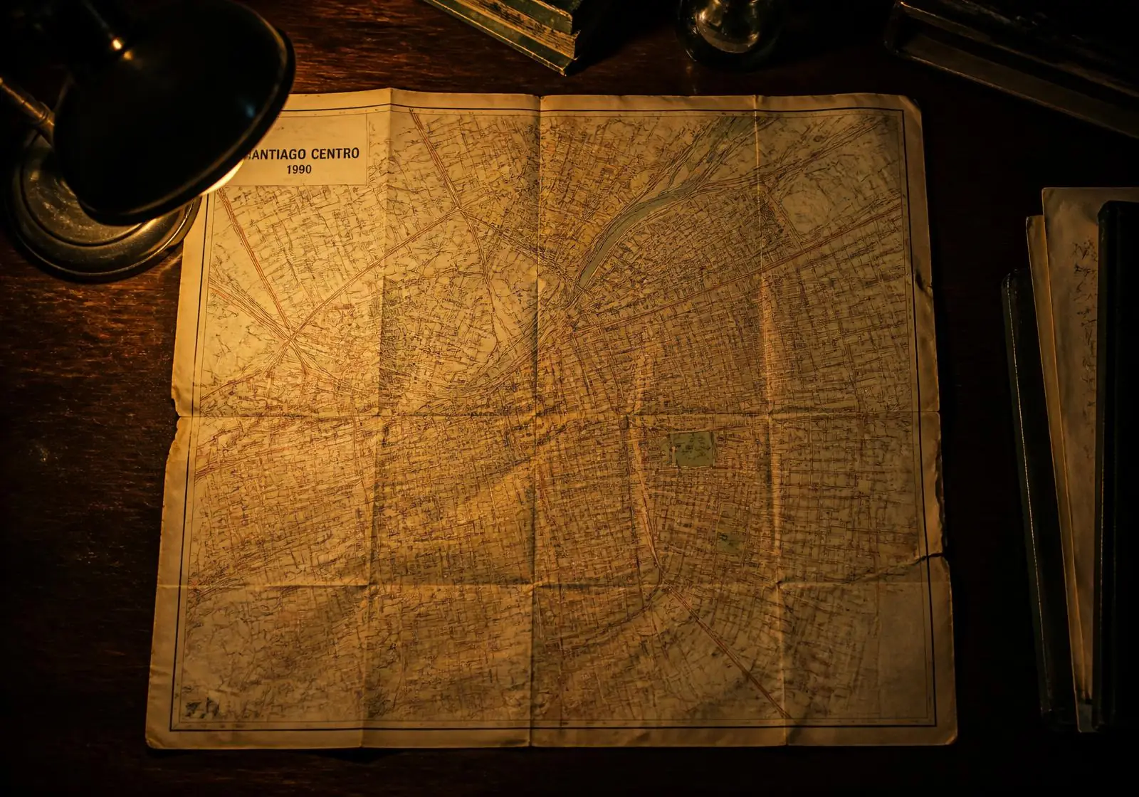 Mapa de papel de Santiago Centro de 1990 sobre un escritorio de madera, con chinchetas marcando los puntos del recorrido